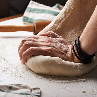 a person kneading dough